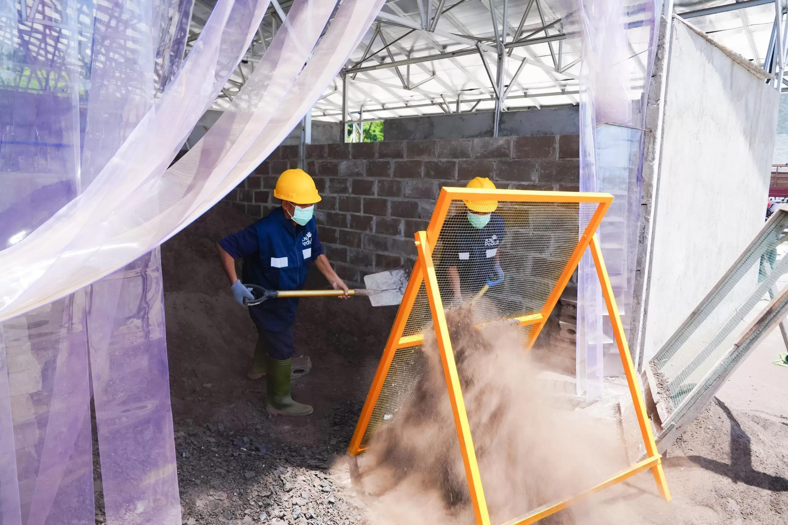 <p>Para warga binaan Lapas Nusakambangan menyaring FABA sebelum dimasukkan ke dalam mesin press untuk diolah menjadi produk konstruksi bernilai ekonomi di Workshop FABA PLN, Nusakambangan. (Dok. PLN)</p>
