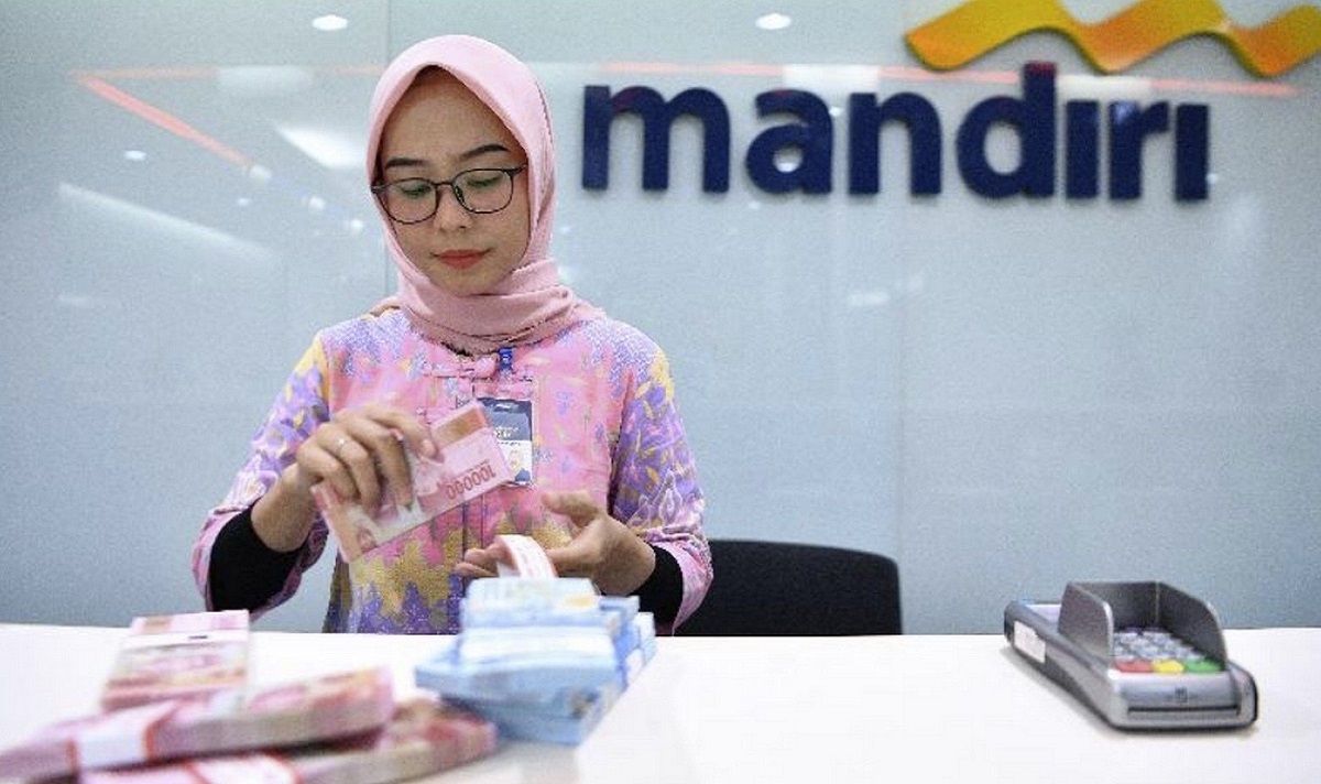 <p>Teller Bank Mandiri yang sedang menghitung uang. Cek status pengajuan KUR Mandiri kini makin mudah! Pantau lewat aplikasi Livin’, call center, atau langsung ke kantor cabang terdekat. Foto: Bank Mandiri</p>

