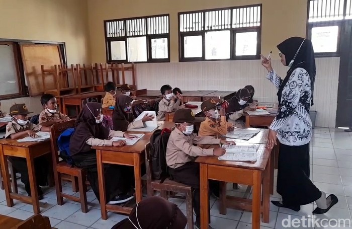 <p>Ilustrasi seorang guru sedang mengajar siswa di kelas. Simak cara cek penerima dan mencairkan insentifi guru non-ASN 2025.</p>
