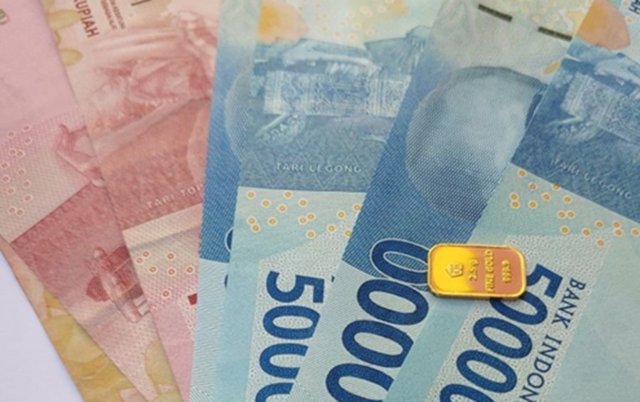 <p>Ilustrasi emas logam mulia dan uang rupiah. Cek daftar harga emas Antam hari ini yang kembali mahal.</p>

