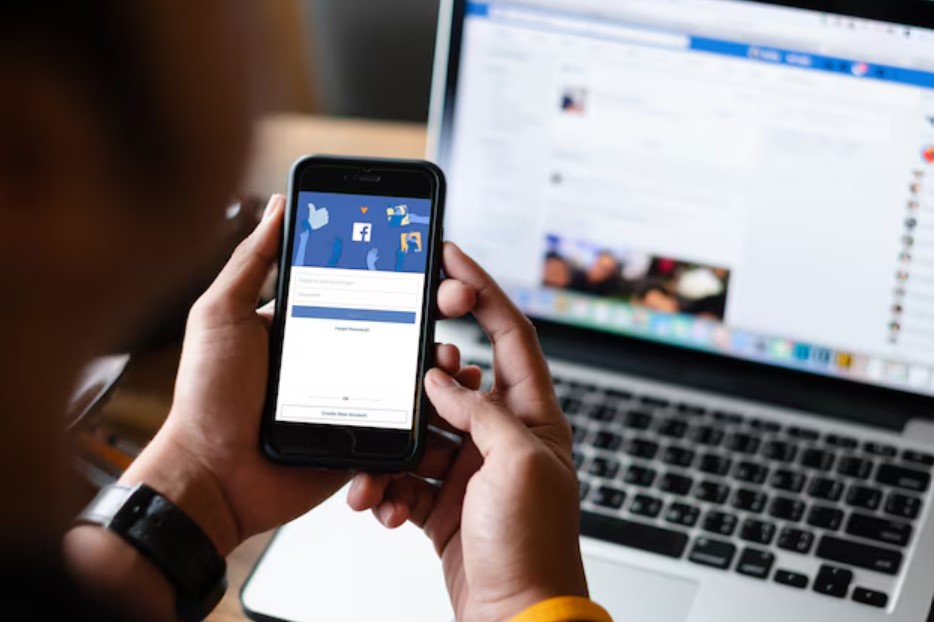 <p>Ilustrasi seorang pengguna membuka aplikasi Facebook di ponselnya, siap melakukan monetisasi akun meski belum punya NPWP. Kini, cukup gunakan NIK KTP sebagai alternatif pengisian TIN agar tetap bisa cuan dari Facebook! Foto: freepik.com</p>
