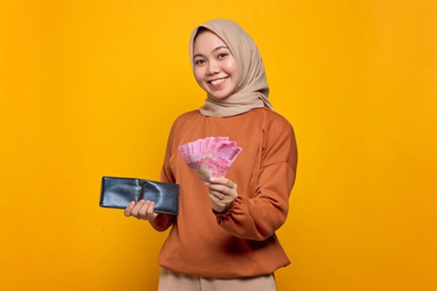 <p>Ilustrasi perempuan menunjukkan uang pecahan rupiah. Berikut panduan lengkap cara cek status penerimaan BSU 2025 sebesar Rp600 ribu. (Foto: Freepik).</p>
