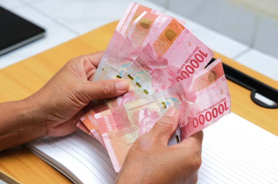 <p>Ilustrasi seorang penerima manfaat tengah menghitung uang bantuan PKH-BPNT yang baru cair di rekening, termasuk bonus Rp400.000 yang disalurkan per 17 Juni 2025. Foto: freepik.com</p>
