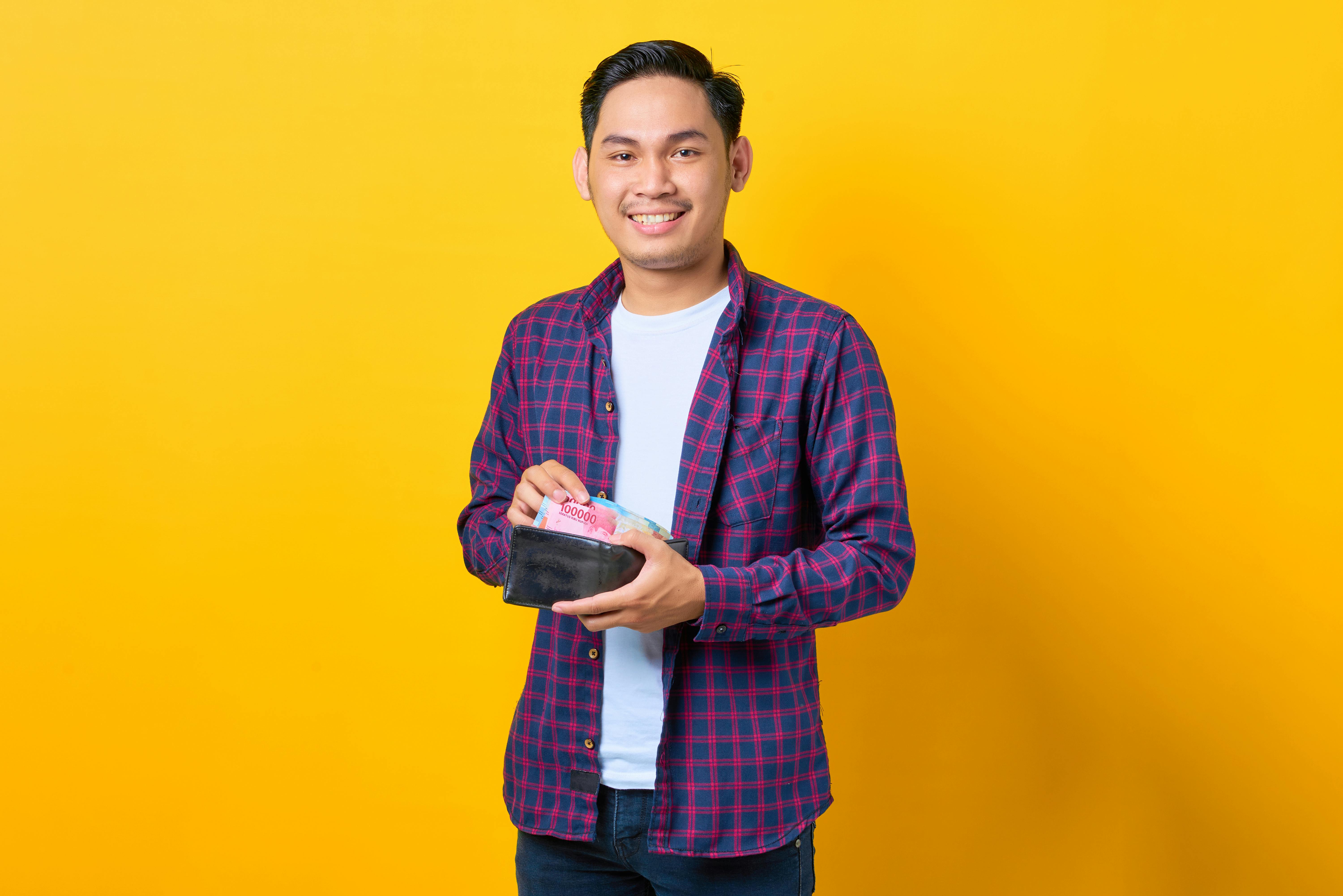 <p>Ilustrasi seorang pria menunjukkan uang rupiah dan bansos. Simak cara verifikasi data penerima bansos, ikuti panduan ini. (sumber: pexels)</p>
